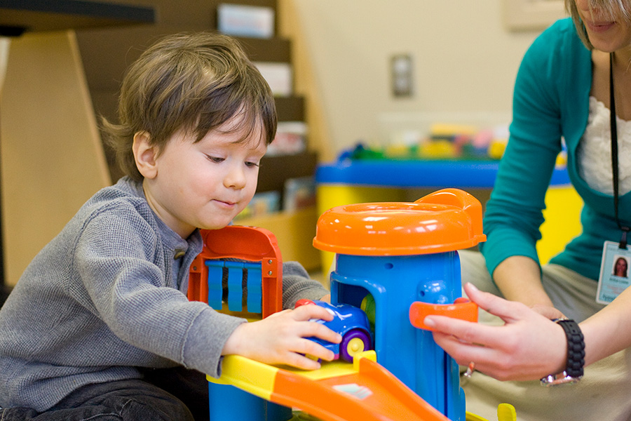 Child playing with a car toy at the PLC