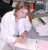 Physician filling out paperwork at a desk