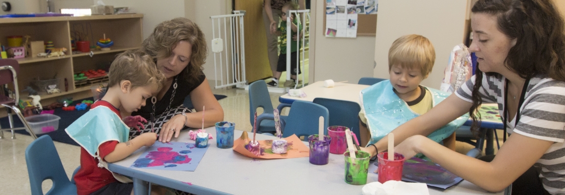 Clinical educators helping children with paint projects 